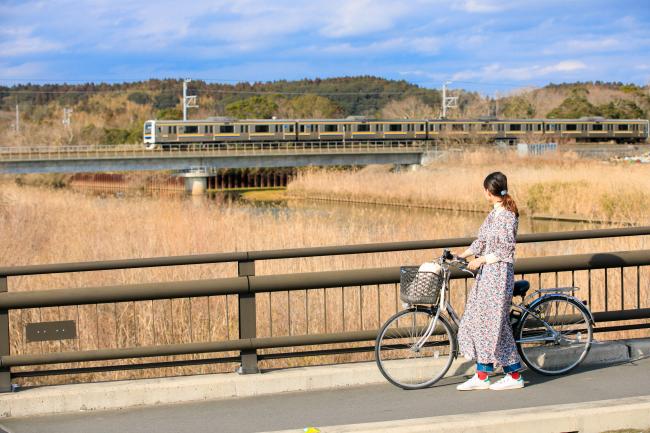 栗山橋から電車を見ている女性の写真