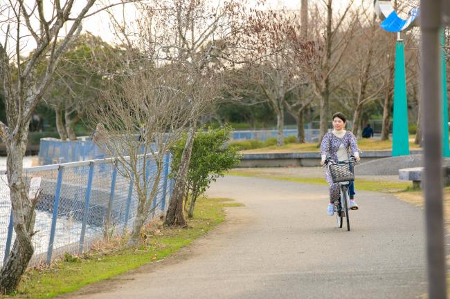 ふれあい坂田池公園で女性が自転車に乗っている写真