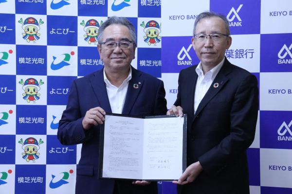 佐藤晴彦町長と熊谷俊行頭取の協定書締結の写真
